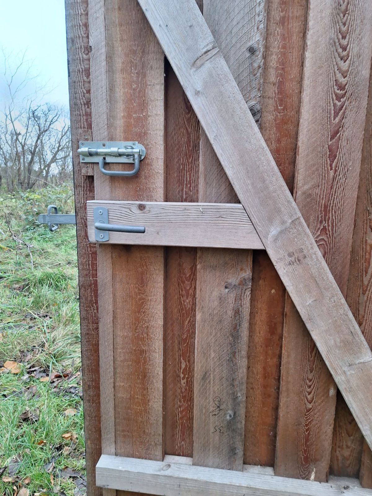 med staldørsgreb og skydelås. Døren åbner udad. 