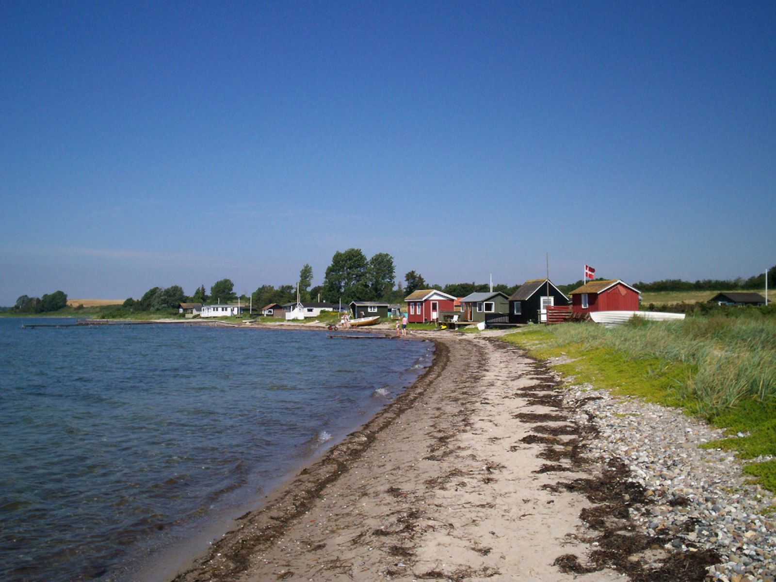 Strandkant med små huse i baggrunden
