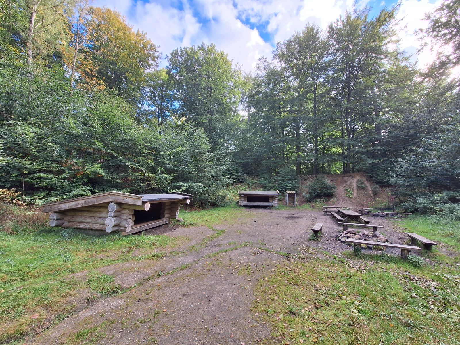 Billedet viser to shelters, to bålsted og bordebænkesæt