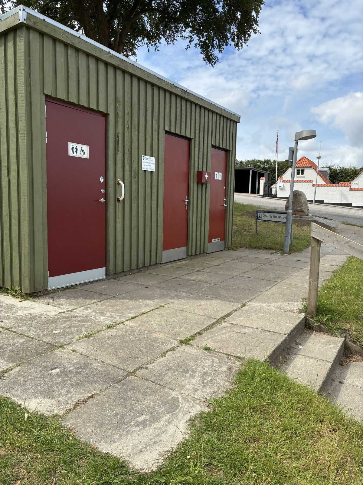 Toiletbygning med flisegang op til.
