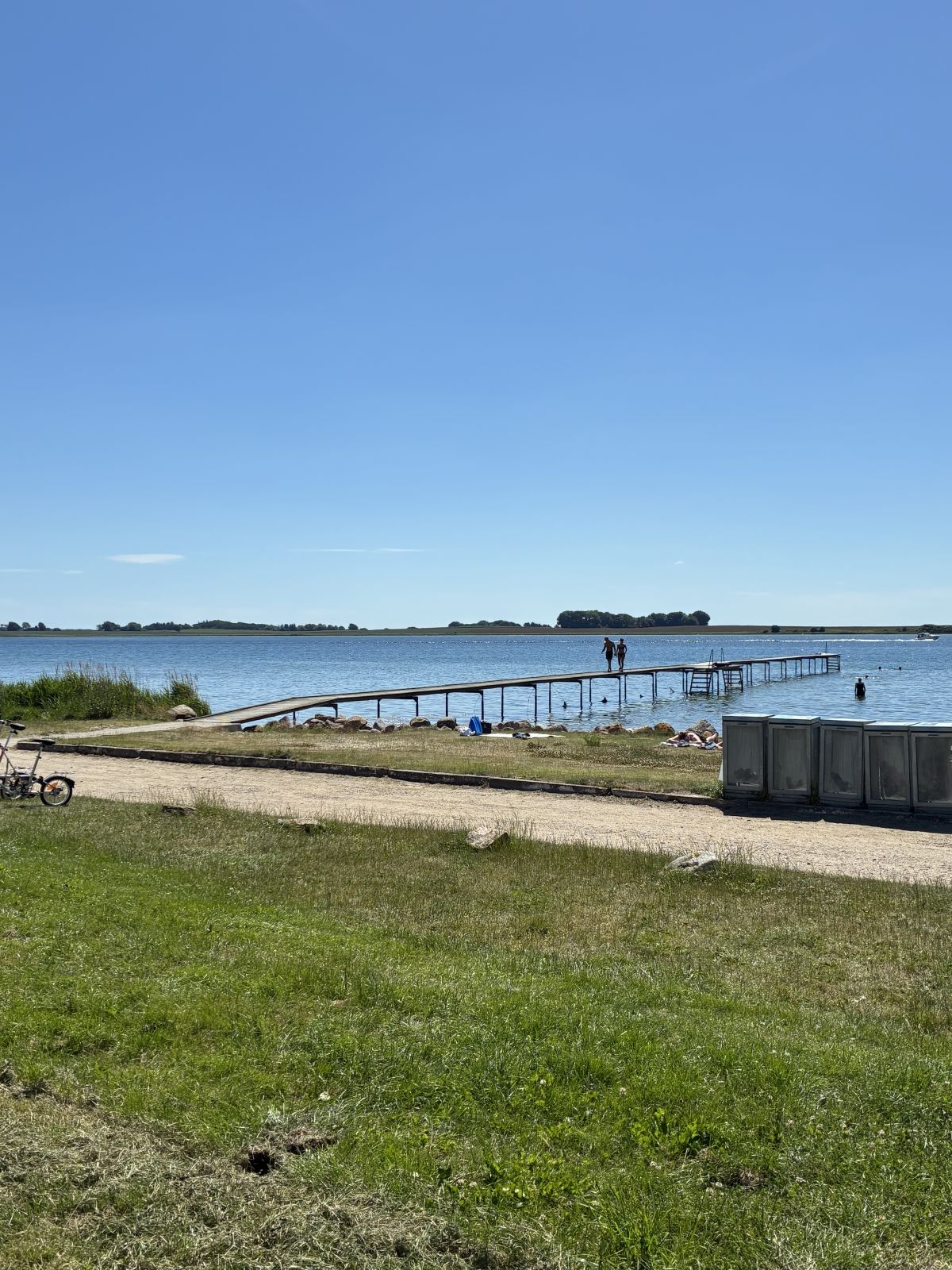 Badebro med grusplads og græsplæne foran