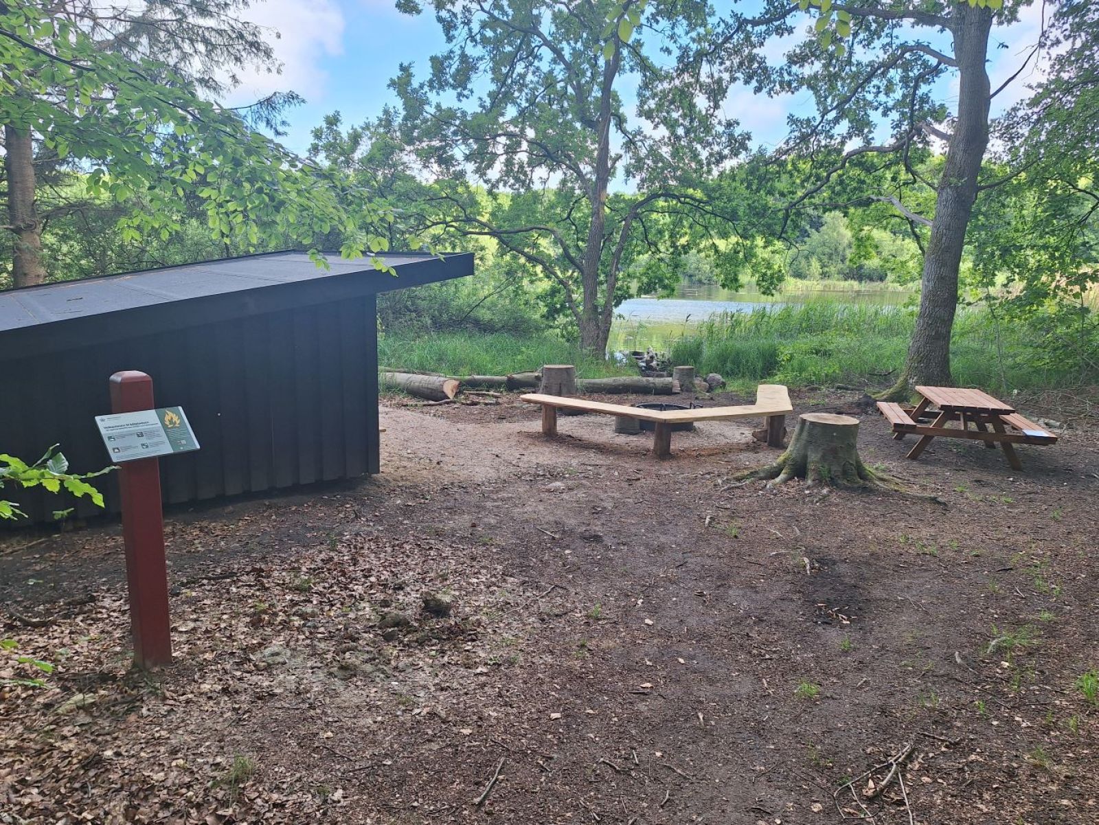 Udsig med shelteret, bålsted og sø