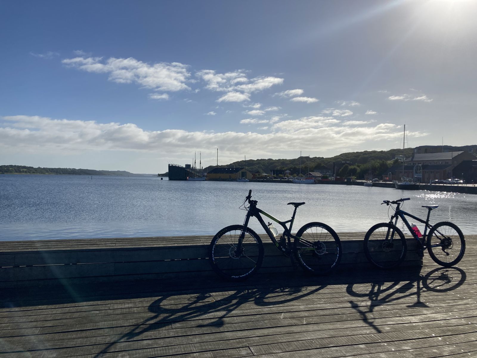 To cykler er parkeret op ad en plint med Mariager Fjord bag sig