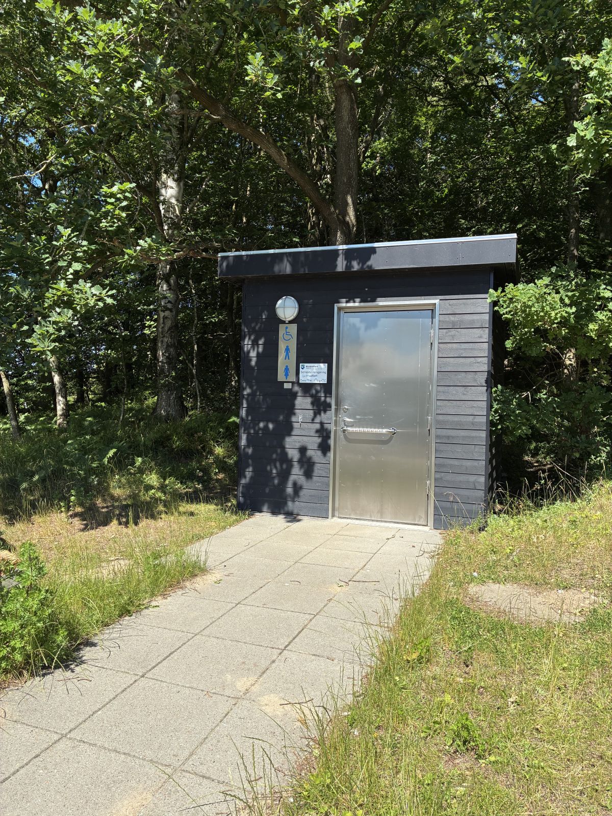 Handicapvenlig toiletbygning med flisegang