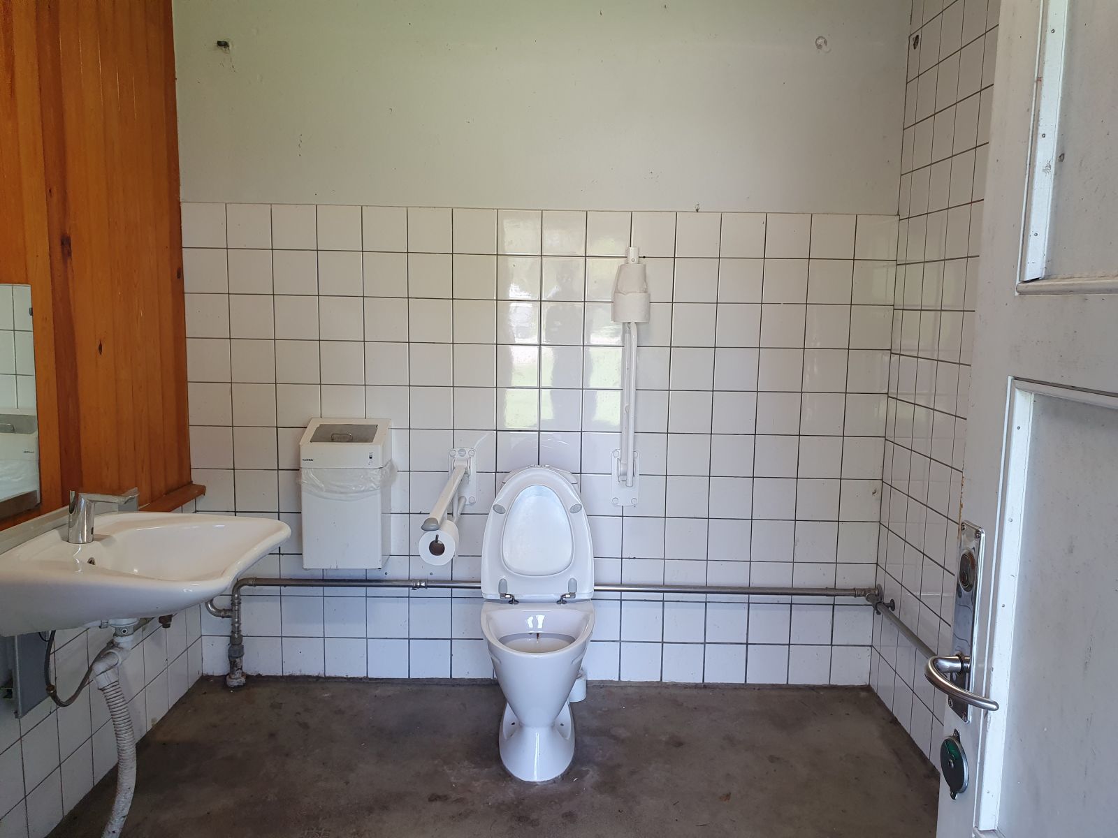 Rummelige toiletbygning.