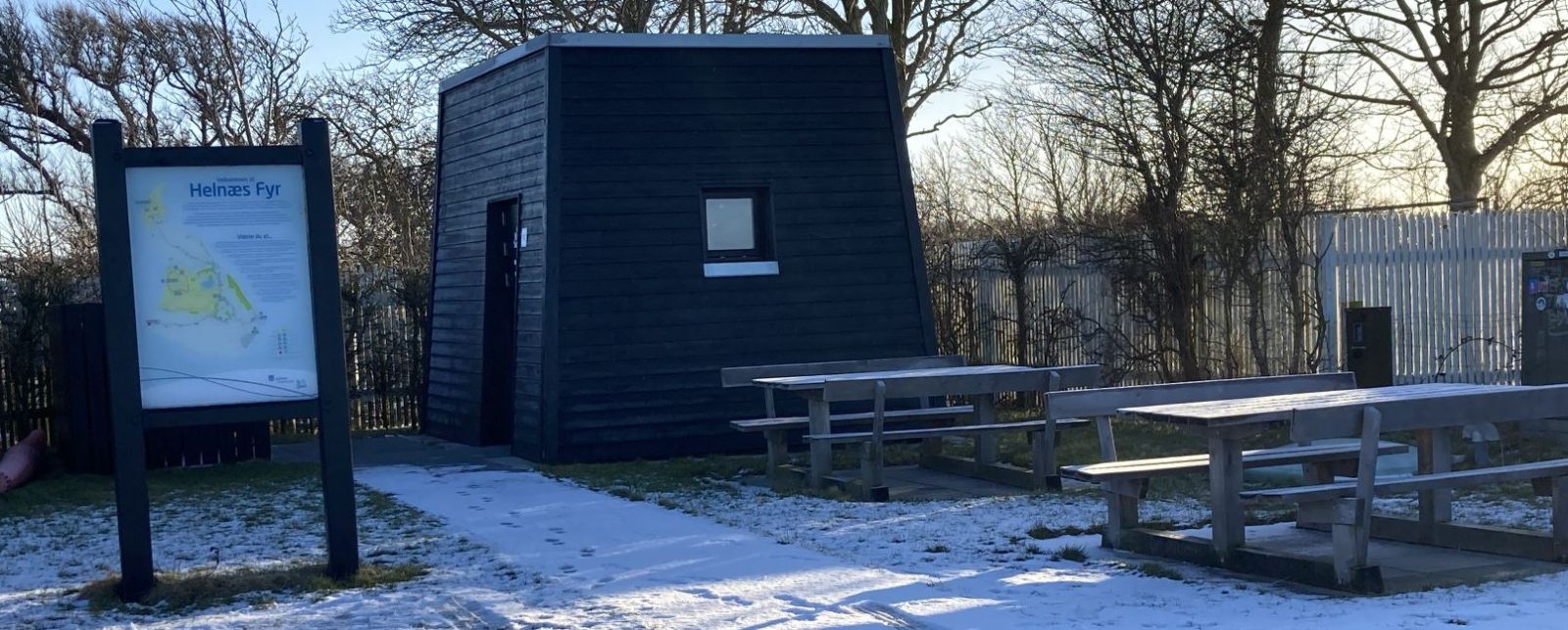 Borde/bænkesættenr står på den grusbelagte P-plads