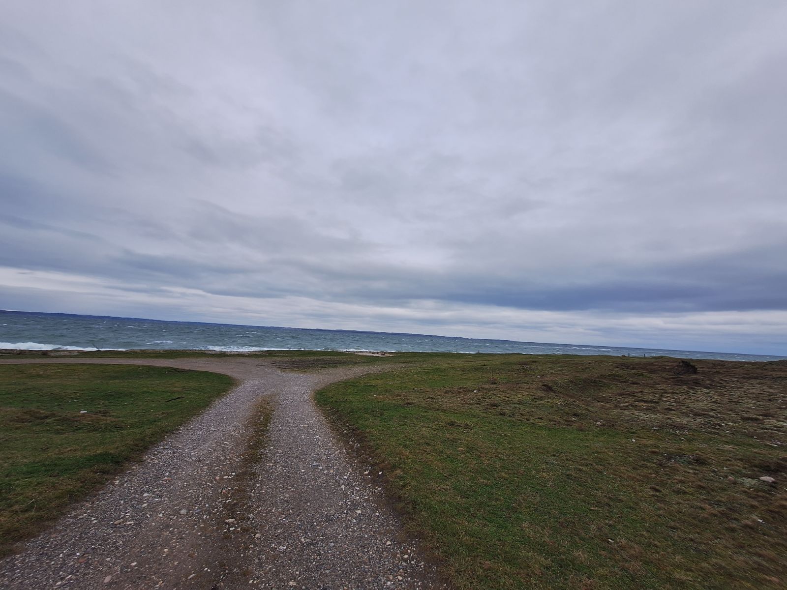 Parkeringspladsen foregår langs grusvejen. 