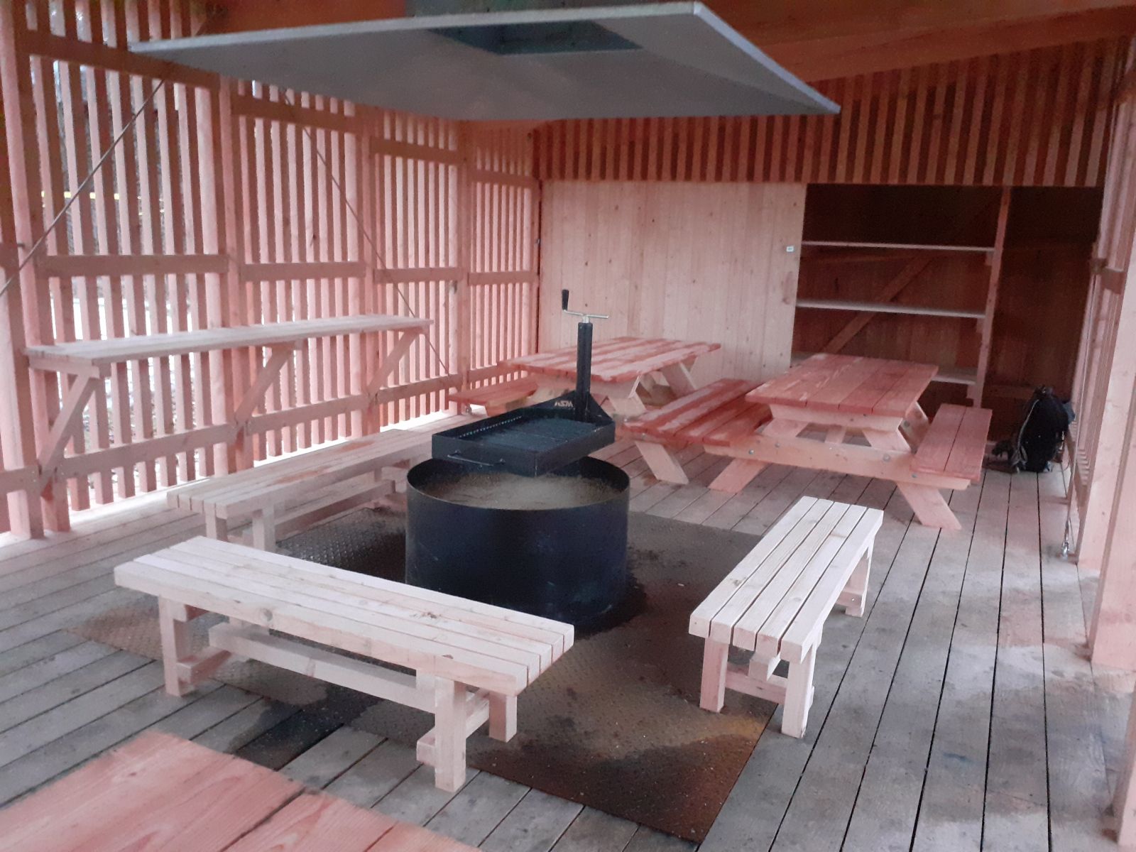 Bålhytten set indefra, bålet, grillen og siddepladesr