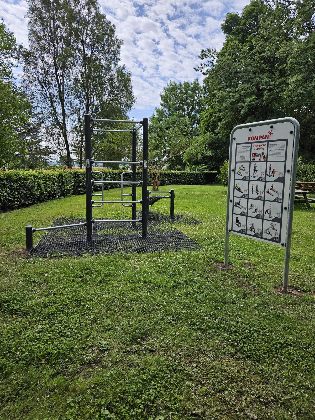 Billede af Træningsredskaber fra Kompan i Lunden. Der er faldunderlag og skilt med hjertevenlige øvelser.