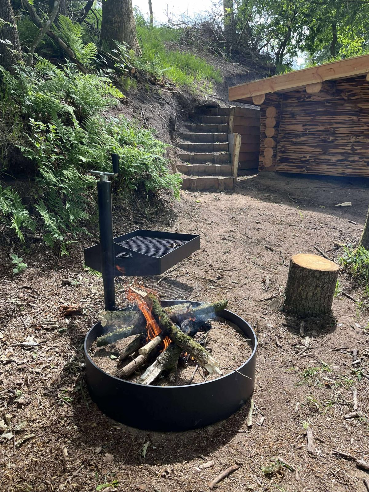 Bålsted med grillrist. Trappen fører op til toilettet.