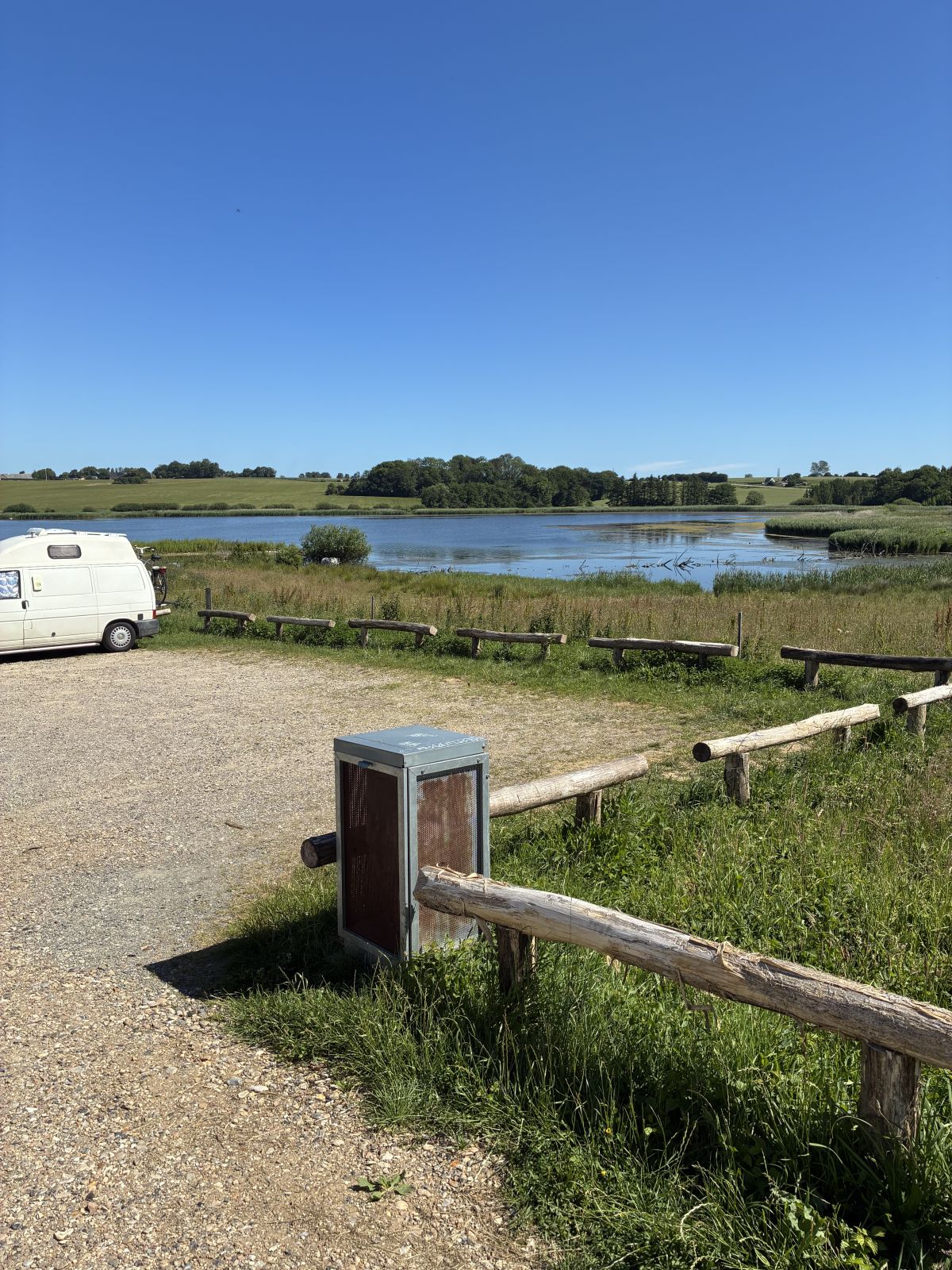 Grusparkeringsplads med udsigt over sø-