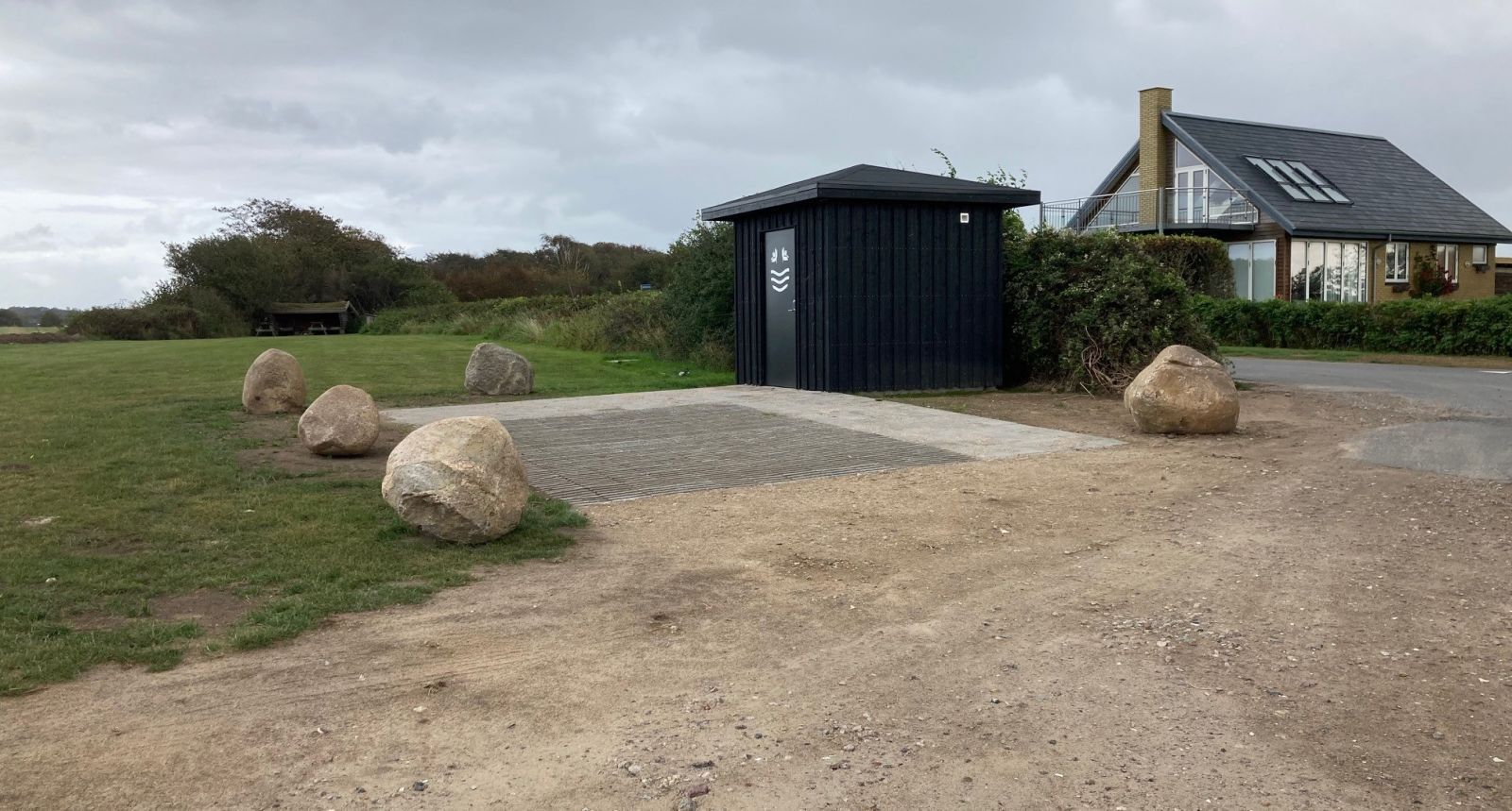 Én P-plads reserveret til handicapbiler. Pladsen er ca. 7 x 3½ m og belagt med fliser. P-pladsen ligger lige ved siden af toilettet.