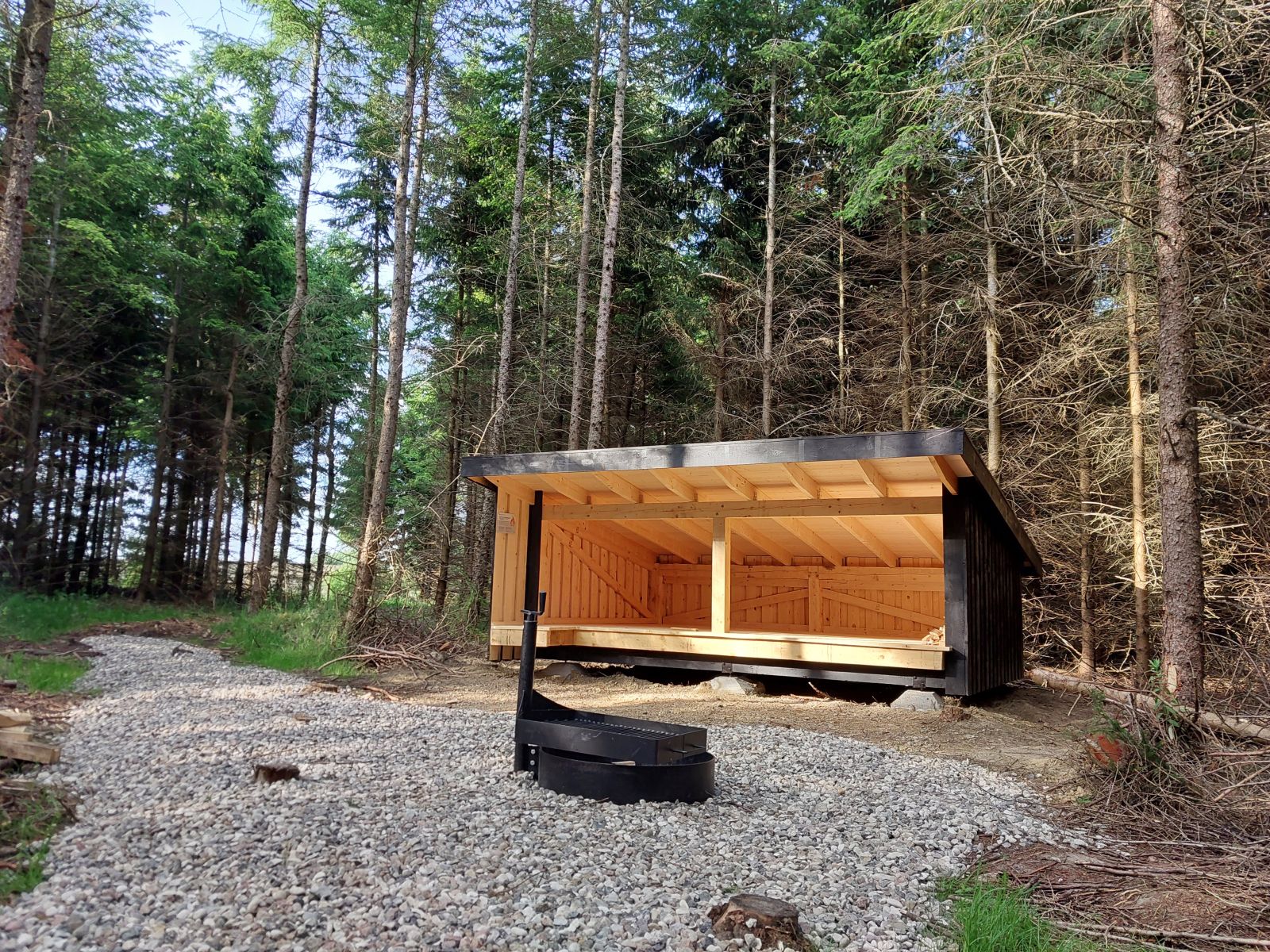Shelter i skov med grillplads foran
