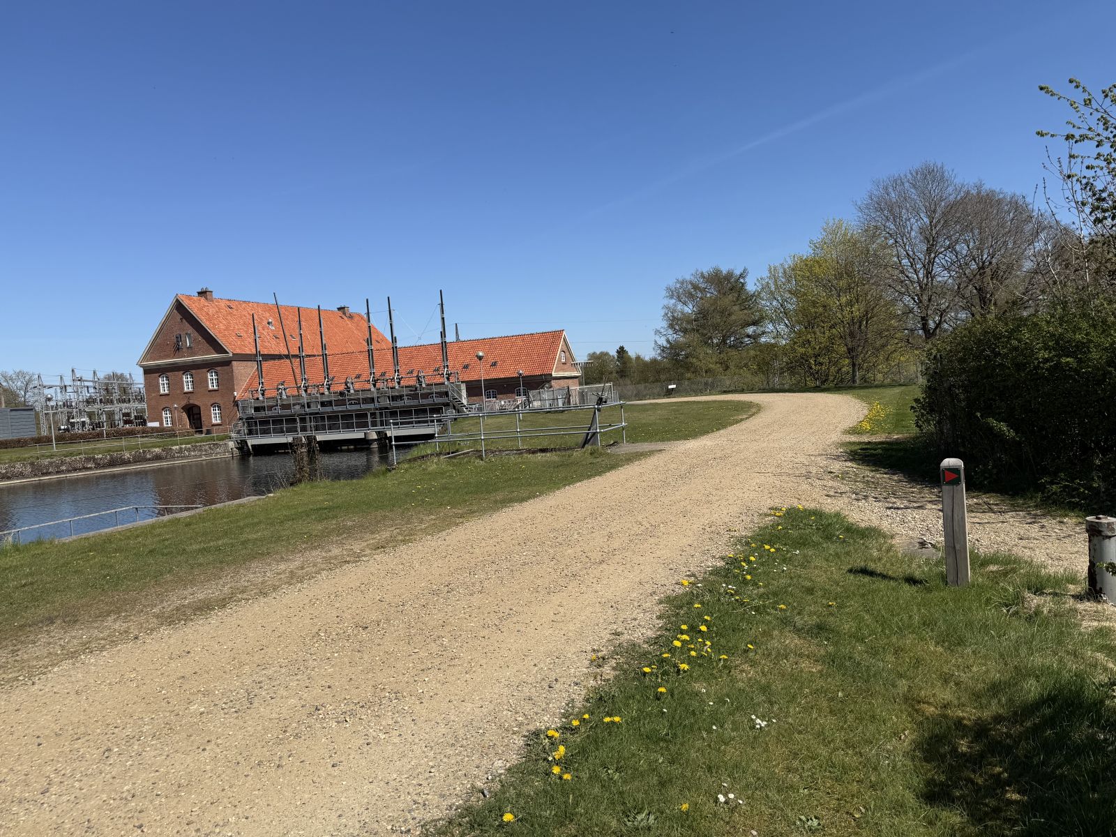 Pilen viser ned i Gudenåcentralens have - men det er vanskeligt at komme over der. Fortsæt ligeud 