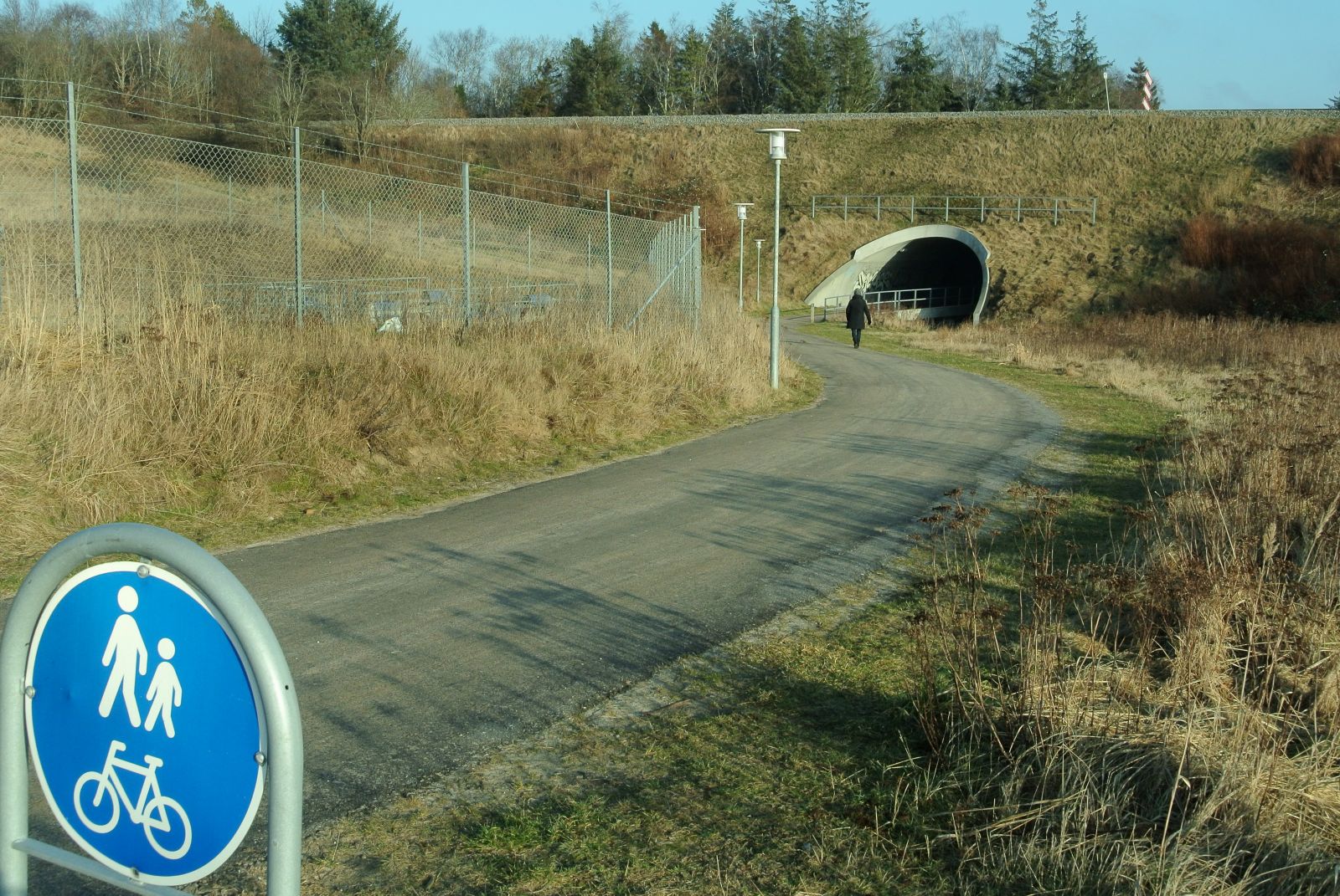 Skiltning med gående og cyklende. Tunnel. Underlag er asfalt. 