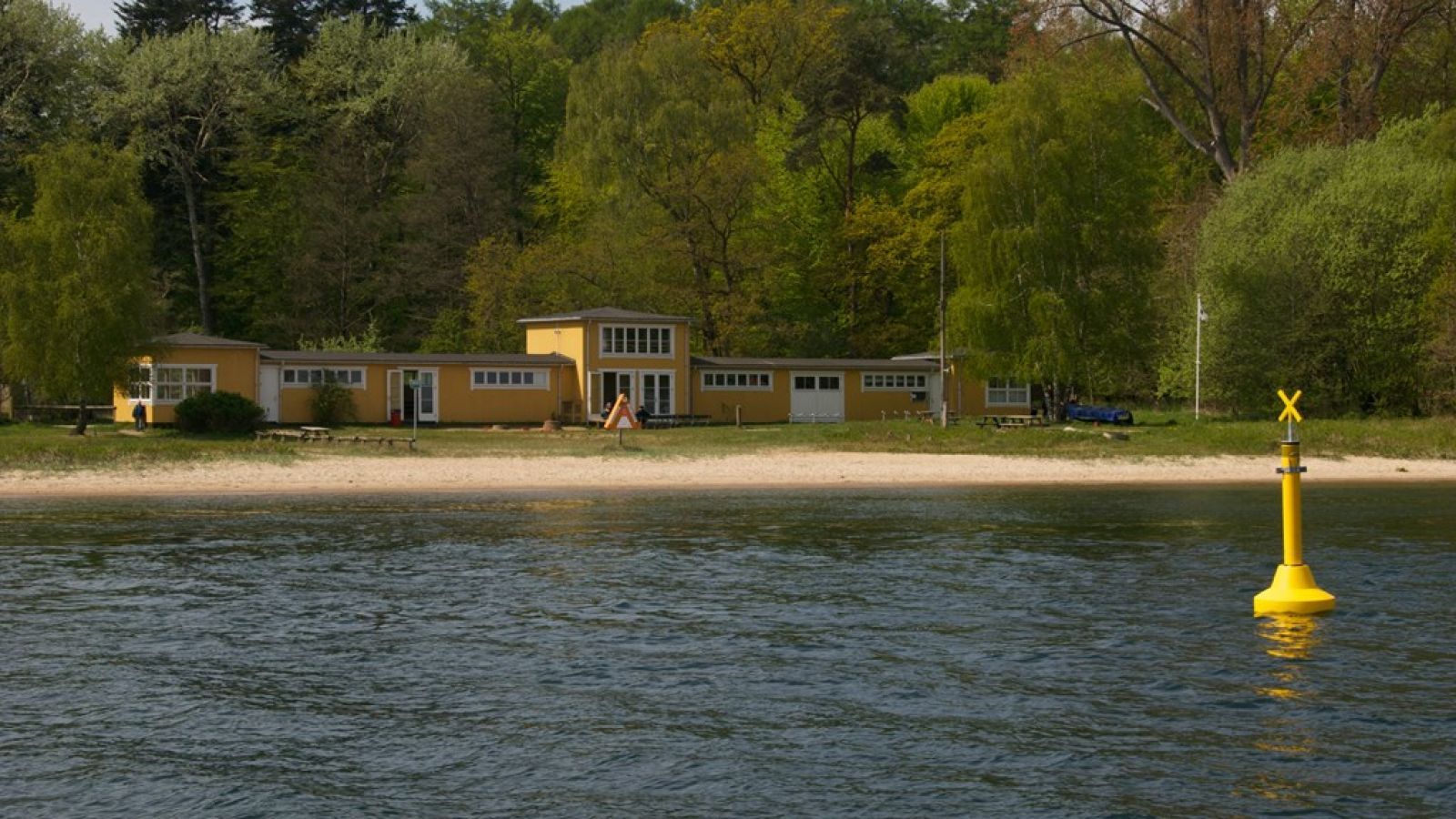 Gul træbygning set fra vandet