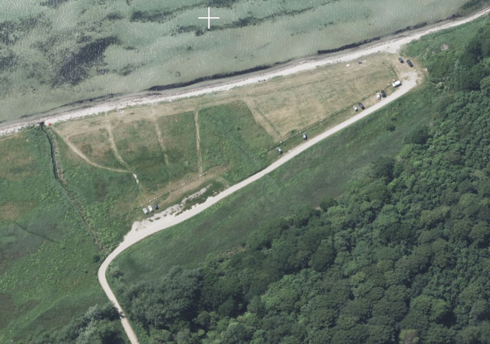 I sommerperioden kan man parkere nede ved stranden. Der er ca. 50-70 m gennem groft græs og sand fra P-pladsen ned til vandet.