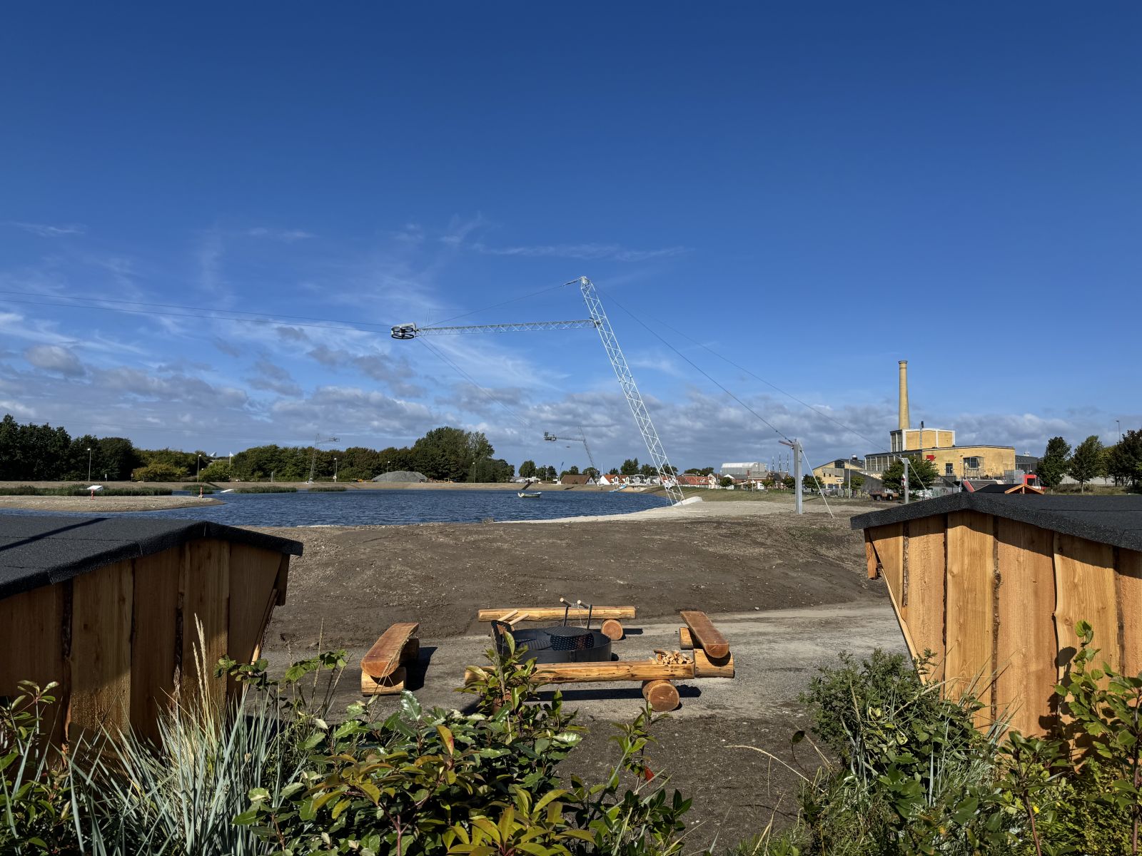 Billedet viser to shelters. Bålsted og bålbænke. Udsigt til søen
