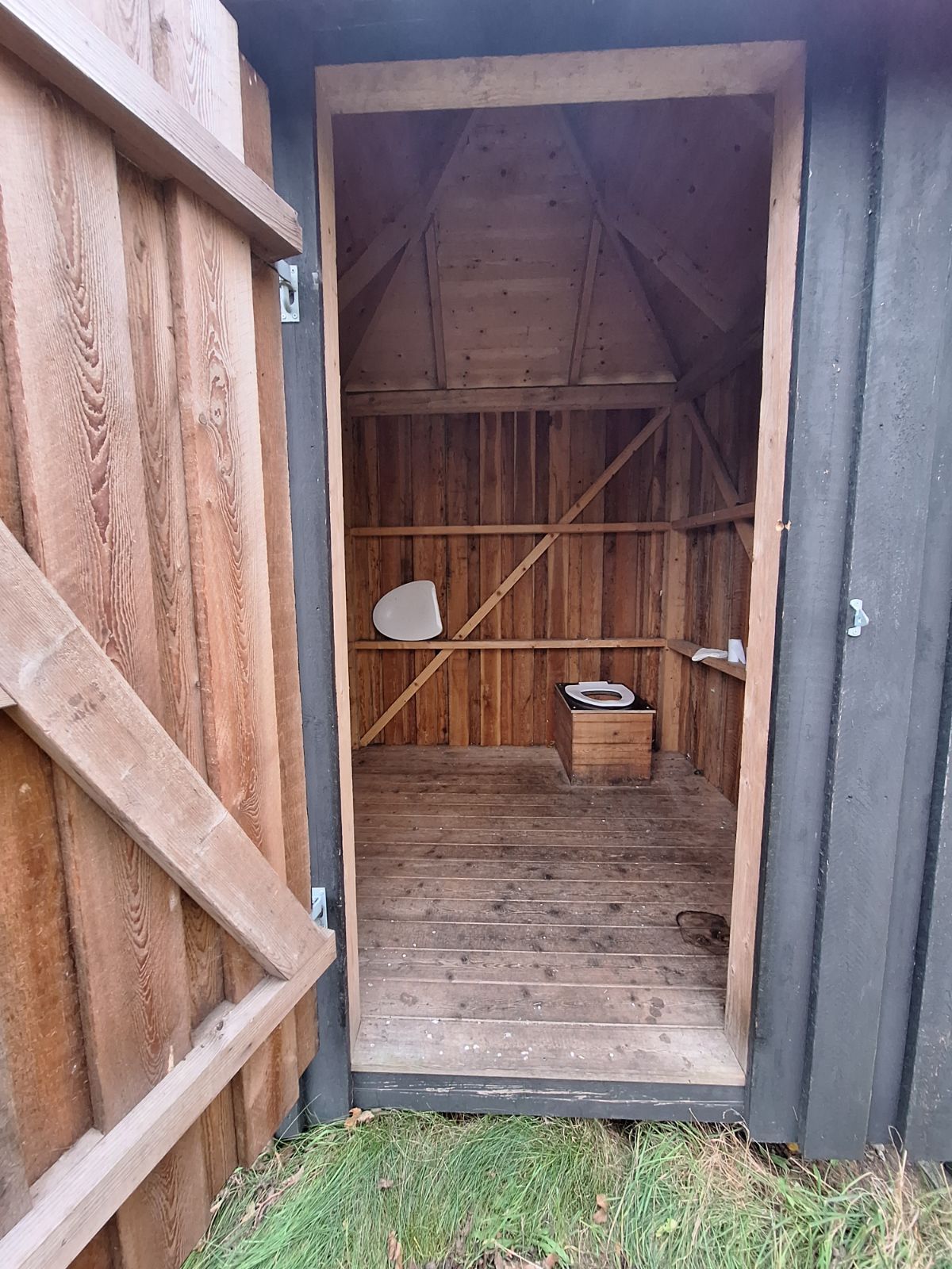 Åbningen til multtoilettet er 82 centimeter i bredden med cirka 130 centimeters frirum fra åbning til toilet som er placeret i højre hjørne bagerst i bygningen fra indgang. Med toiletbræt. Stort frirum til venstre på små 1x2 m. Underlag er træbrædder. 