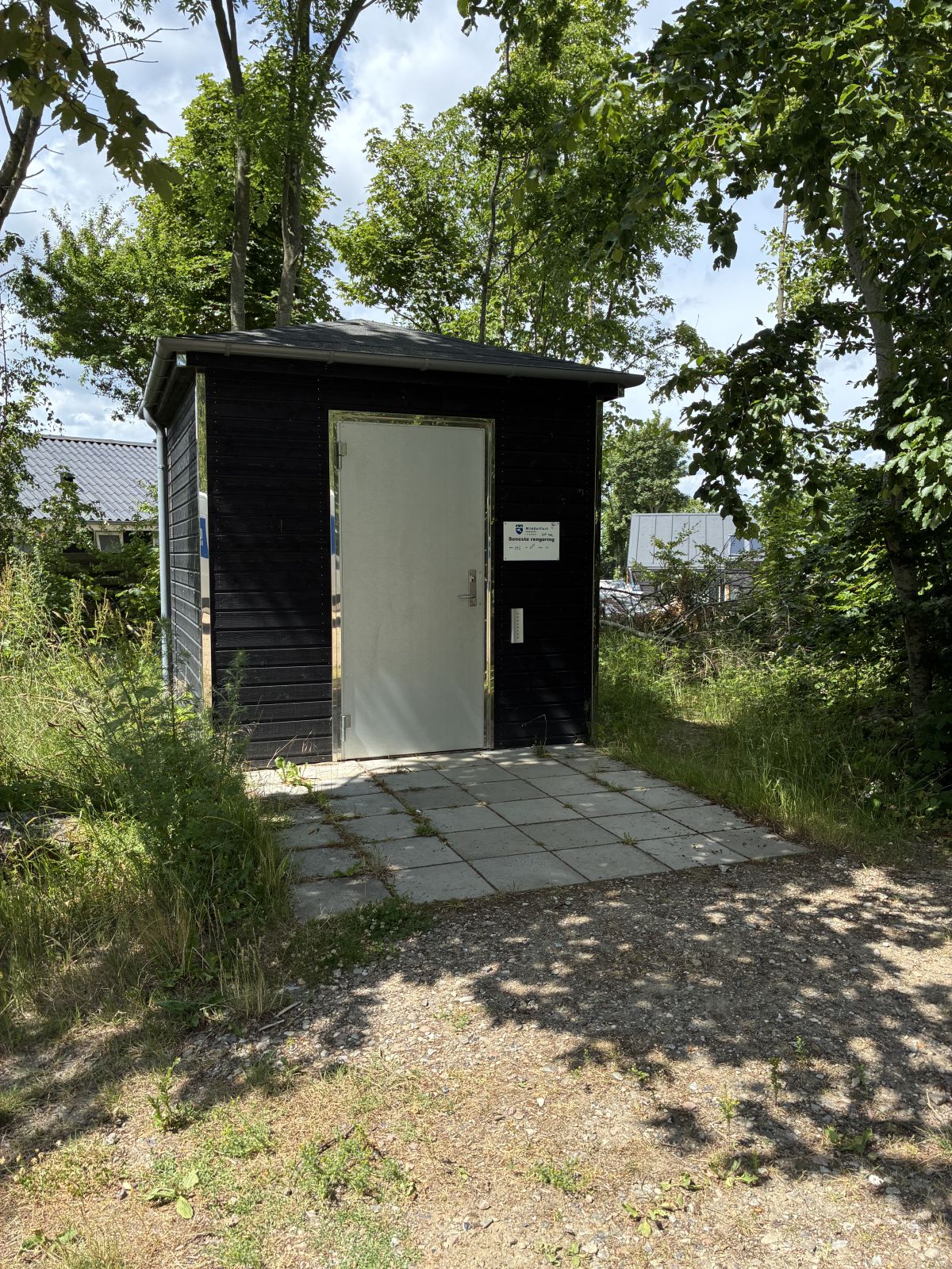 Toiletbygning med flisebelægning omkring