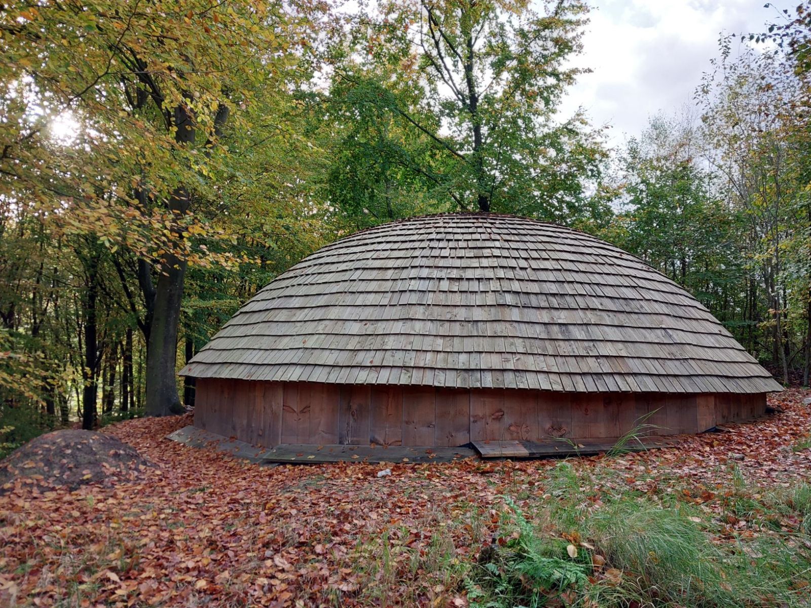Træbygning med rund top mellem træer