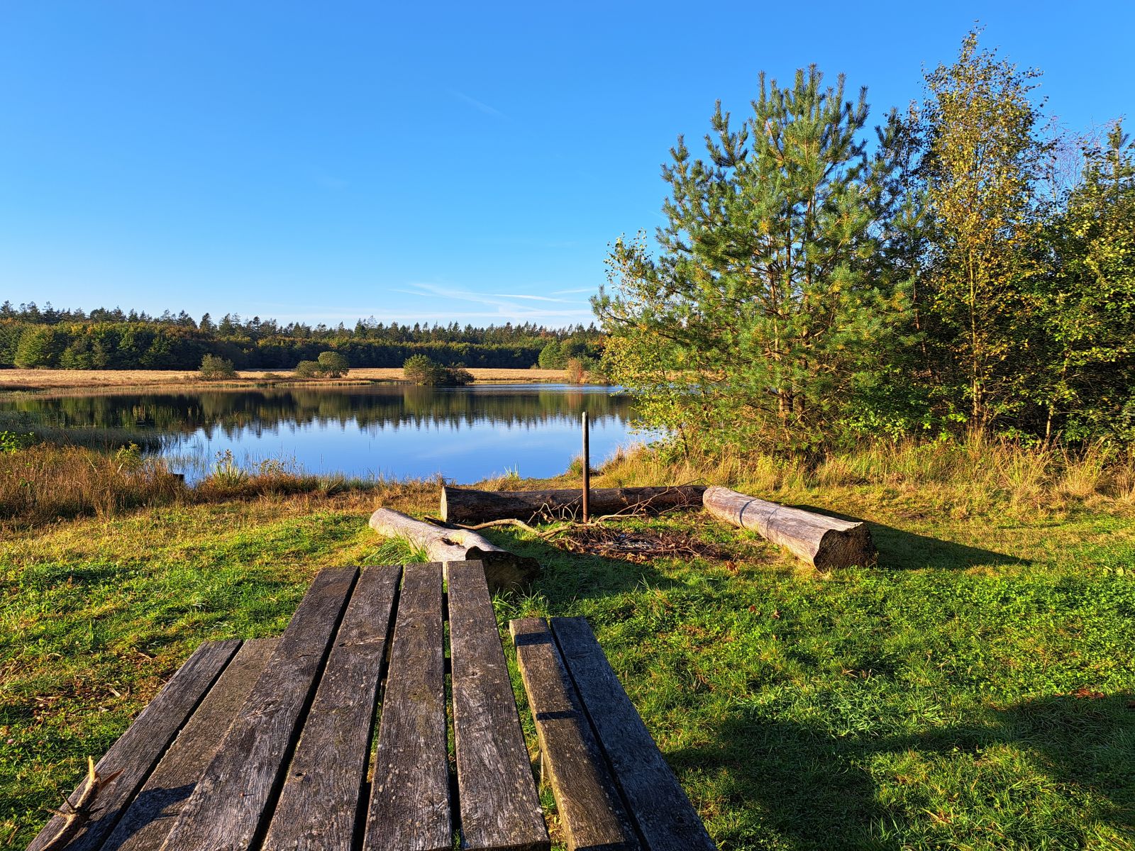 Lige ved siden af p-pladsen findes et bålsted og borde/bænkesæt med en fin udsigt over søen