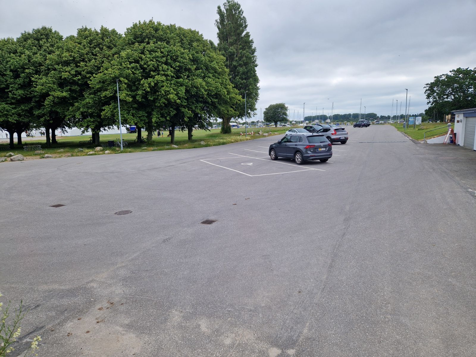 Stor asfalteret parkeringsplads ved Hestehovedet med vandet i baggrunden