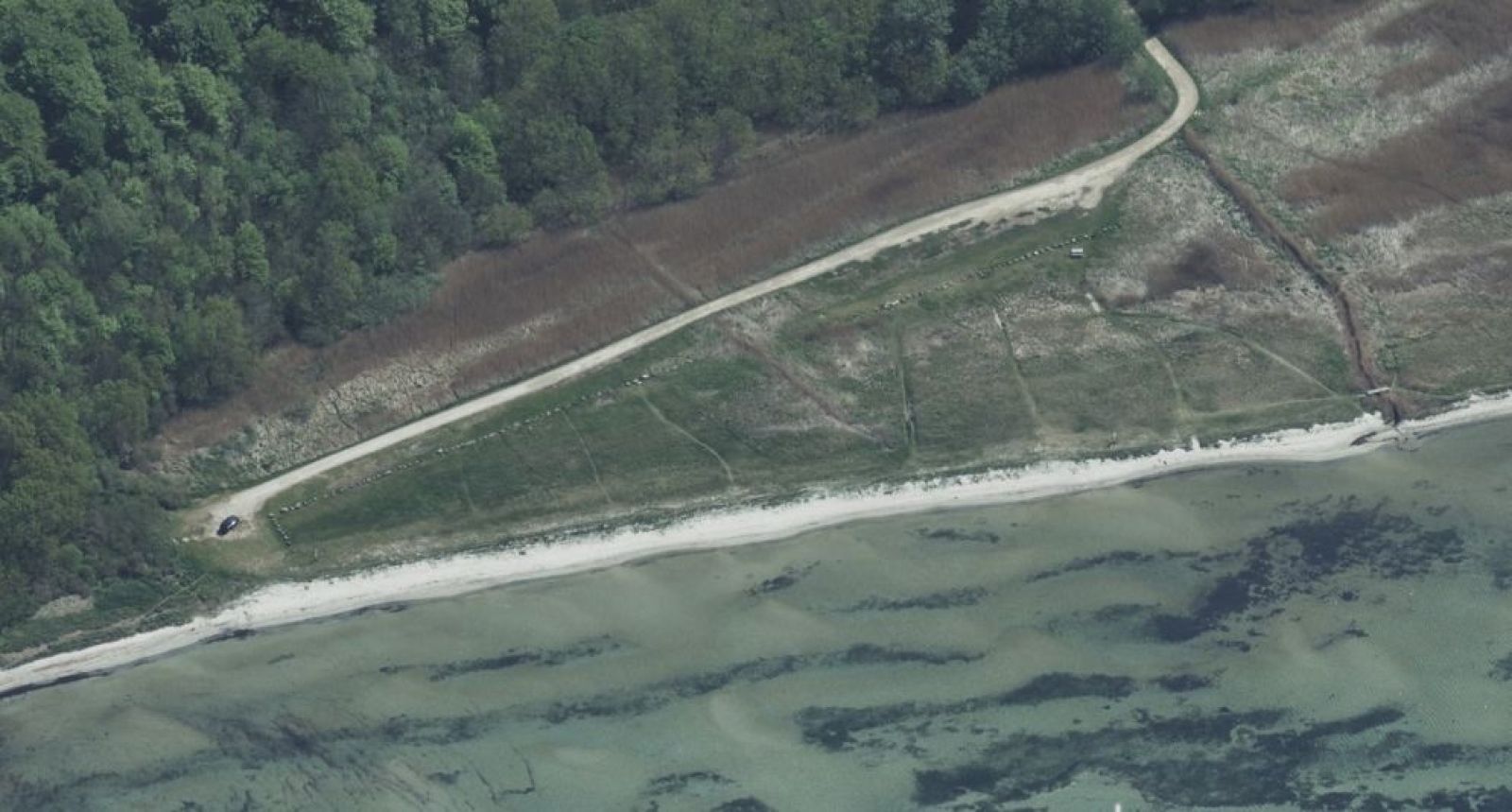 I sommerperioden kan man parkere nede ved stranden. Der er ca. 50-70 m gennem groft græs og sand fra P-pladsen ned til vandet.