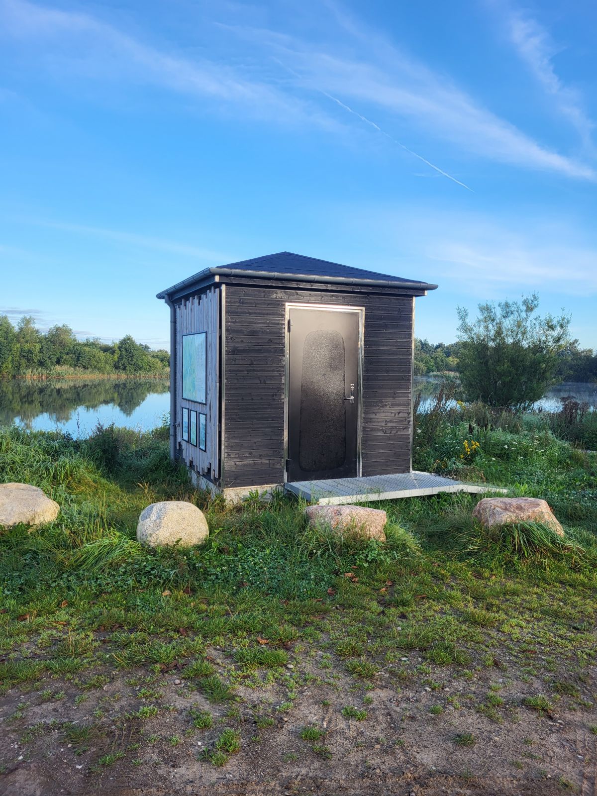 Billede af toiletbygningen, hvor vandposten er på siden.