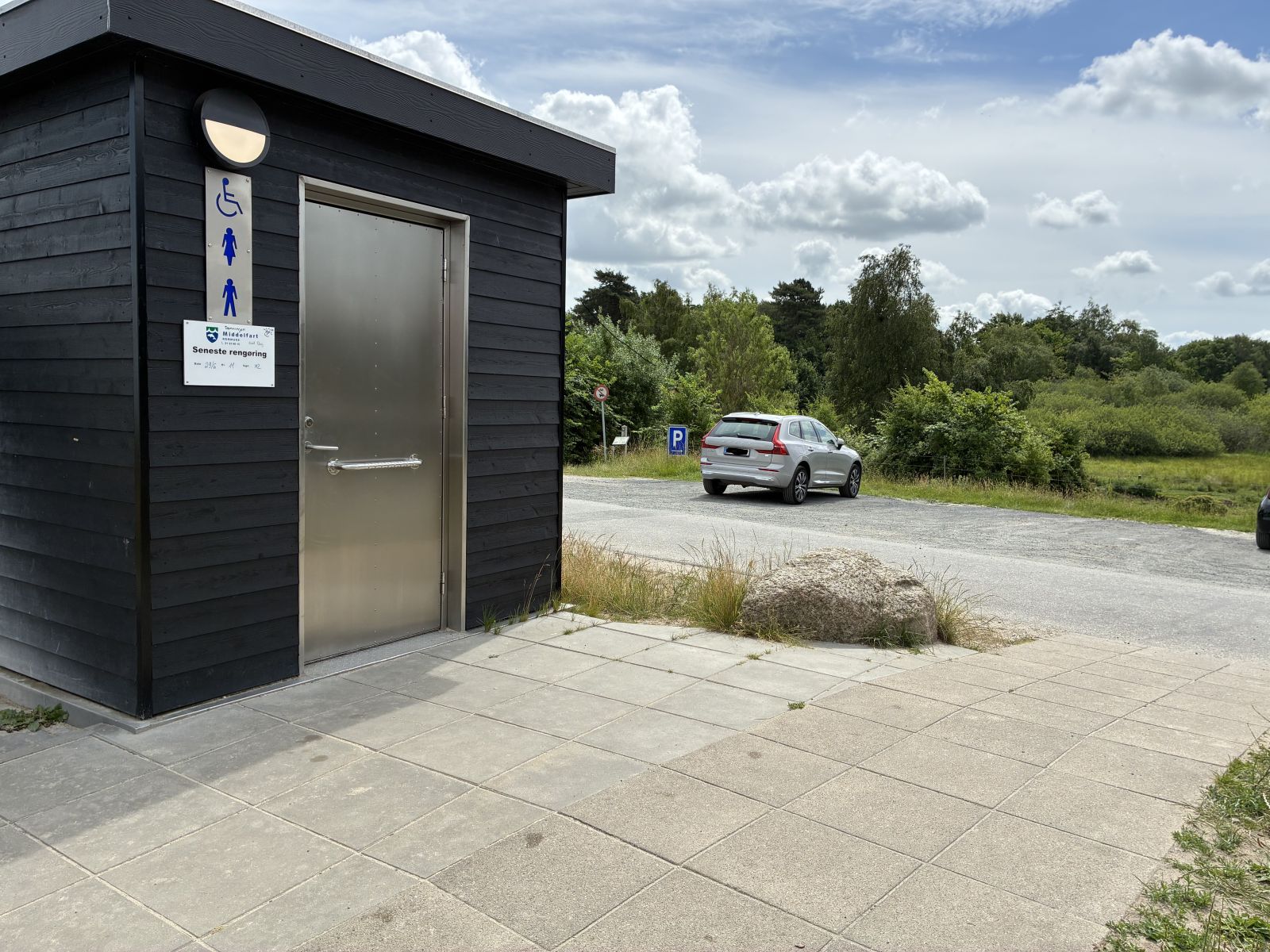 Toiletbygning med flisebelægning omkring