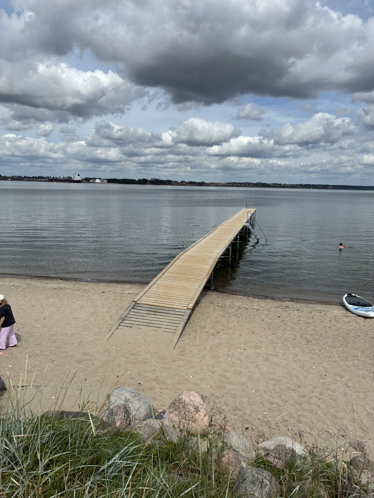 Badebro der går ud i stille vand