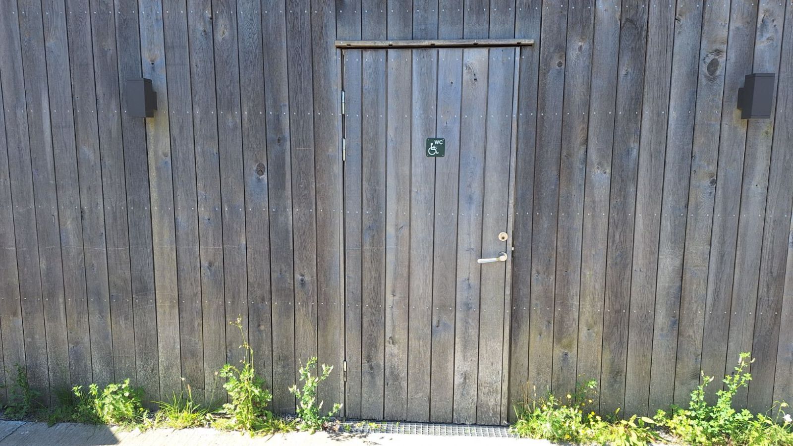 En toiletdør i en træbygning.