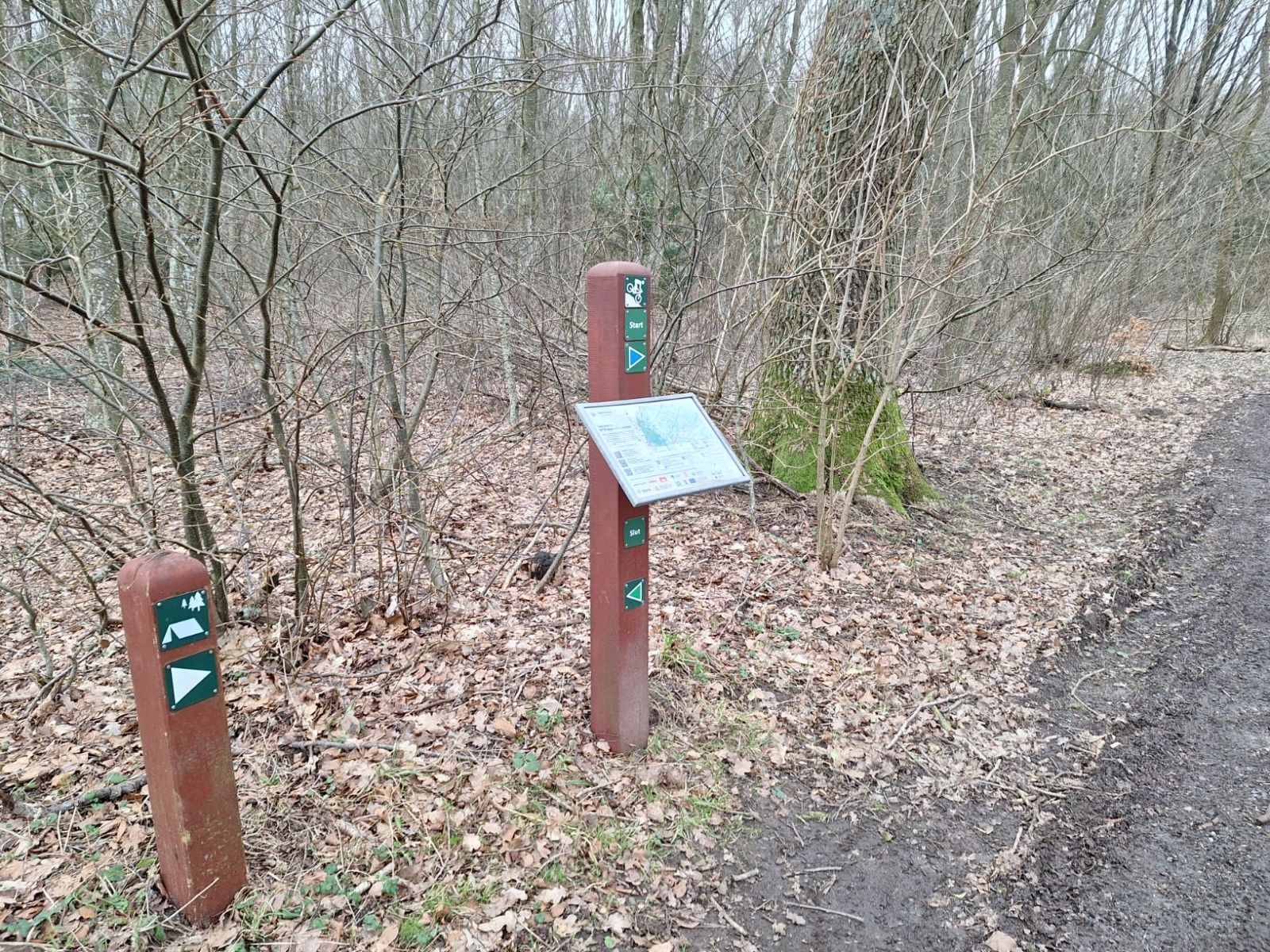 Vejviser til shelterpladsen samt oversigtskortet med mountainbike pile.