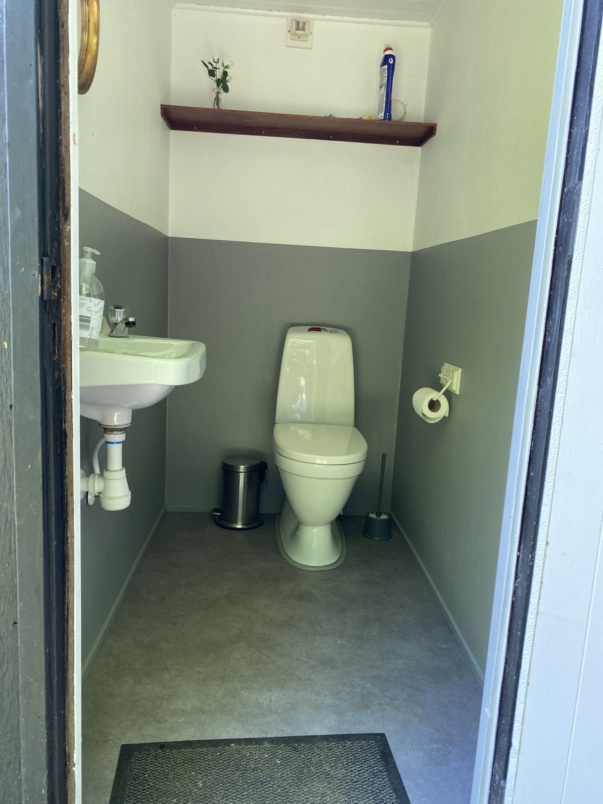 Toilettet med fint porcelænstoilet og håndvask.