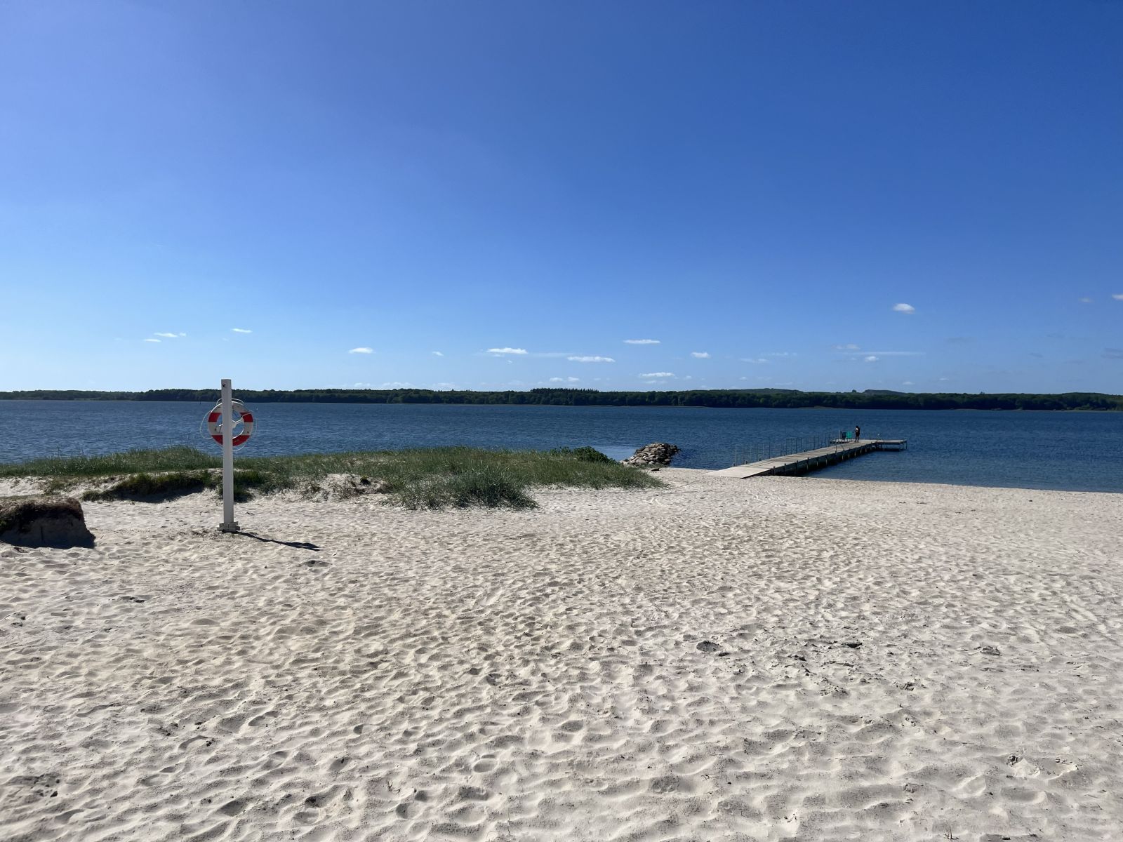 Sandstrand med badebro og redningskrans