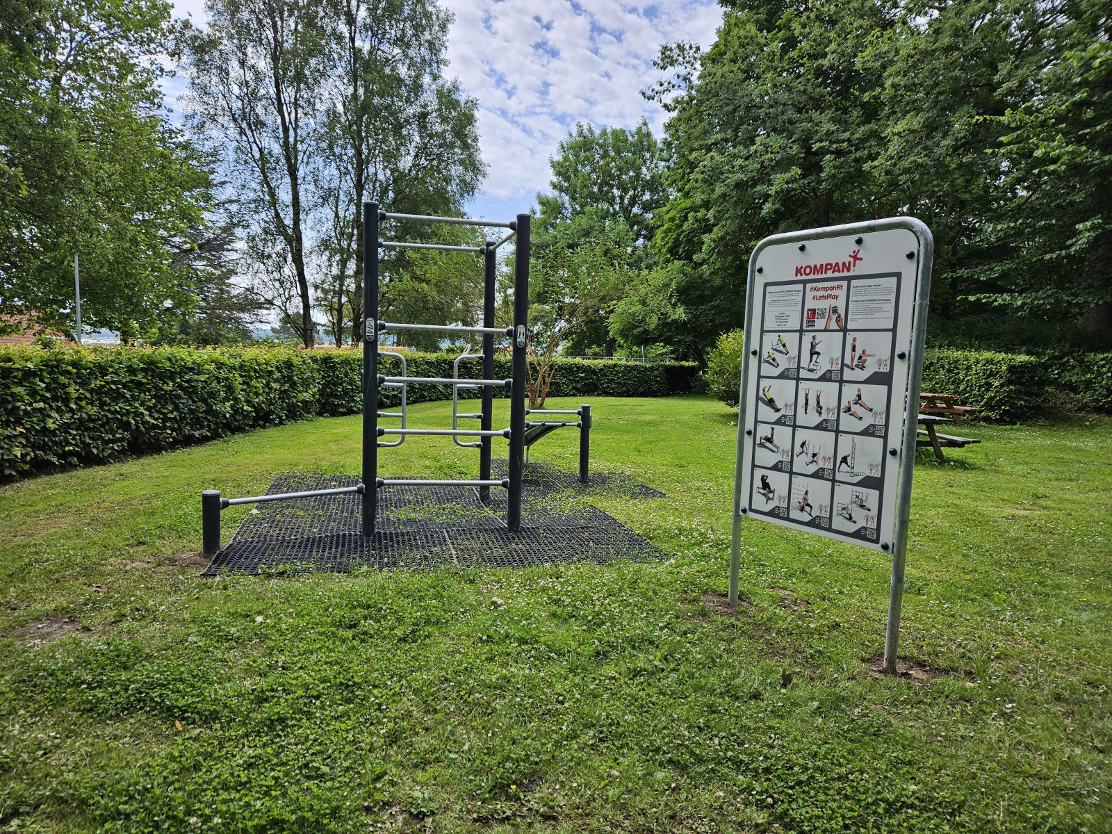 Billede af Træningsredskaber fra Kompan i Lunden. Der er faldunderlag og skilt med hjertevenlige øvelser.