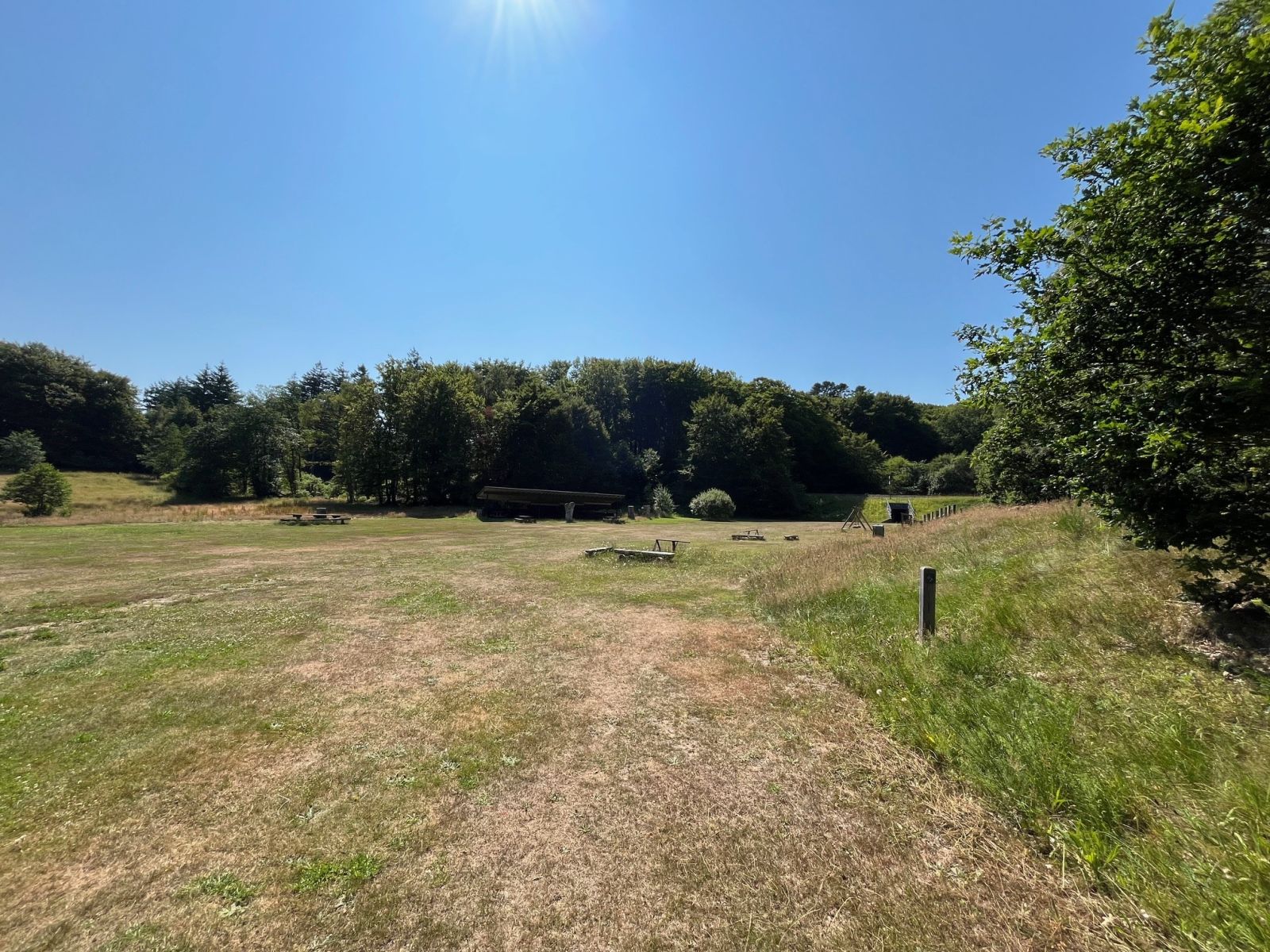 Legeplads. Underlag er græs/jord.