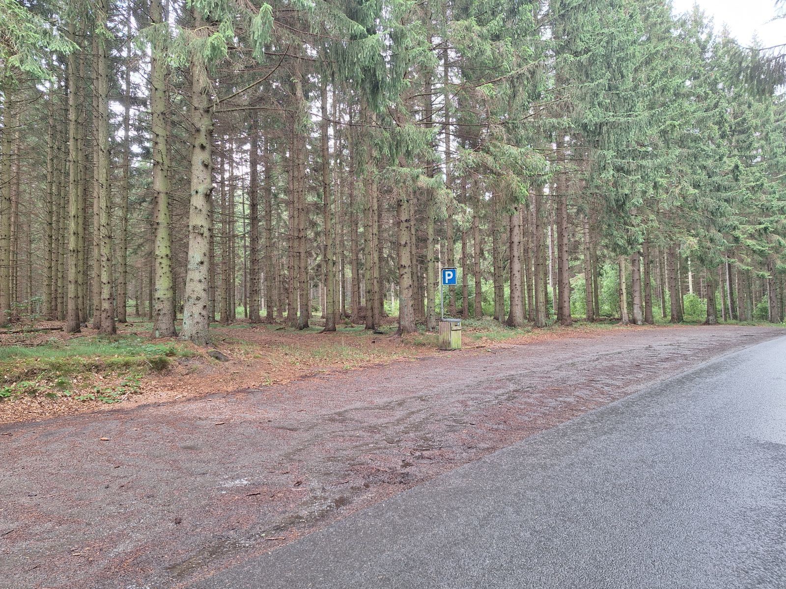 En grusbelagt plads langs med en asfaltvej.