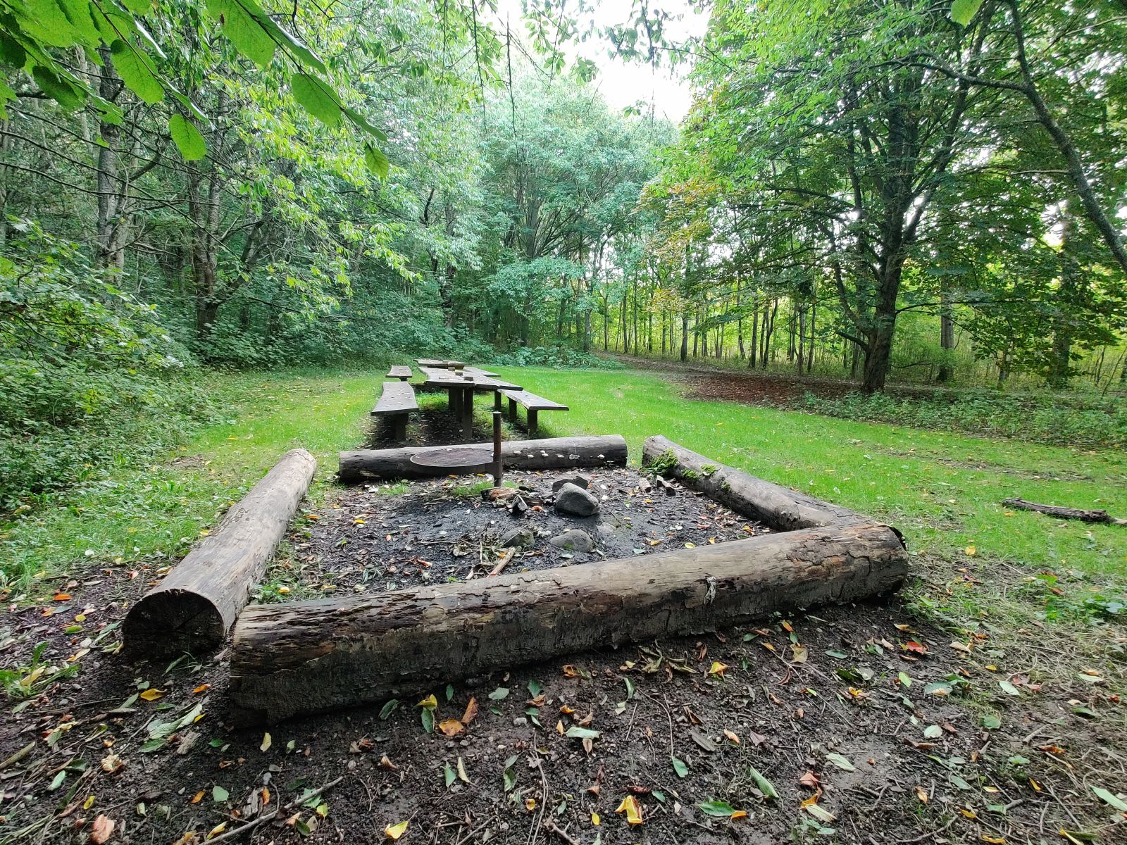 Bålpladsen indeholder bålsted med grillrist og to langborde