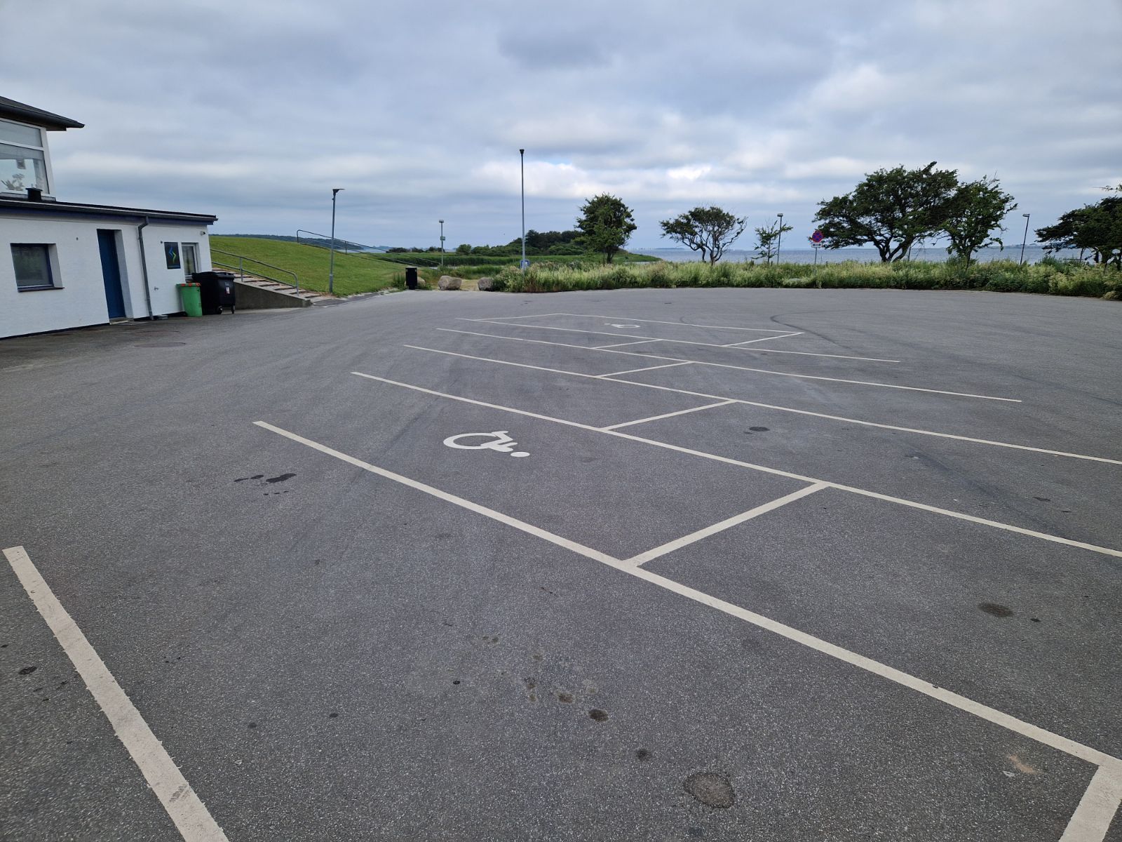 Stor asfalteret parkeringsplads ved Hestehovedet med vandet i baggrunden